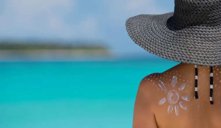 a lady with sunscreen on her back in shape of a sun